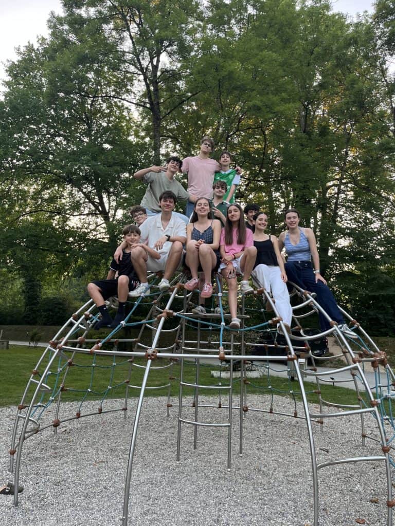 Groupe d'adolescents souriants sur une structure d'escalade en parc
