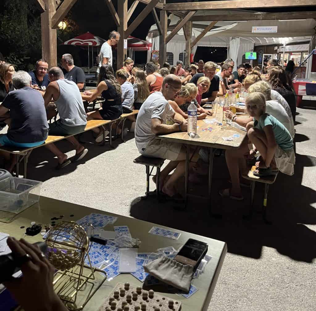 Soirée bingo en plein air avec familles autour de tables
