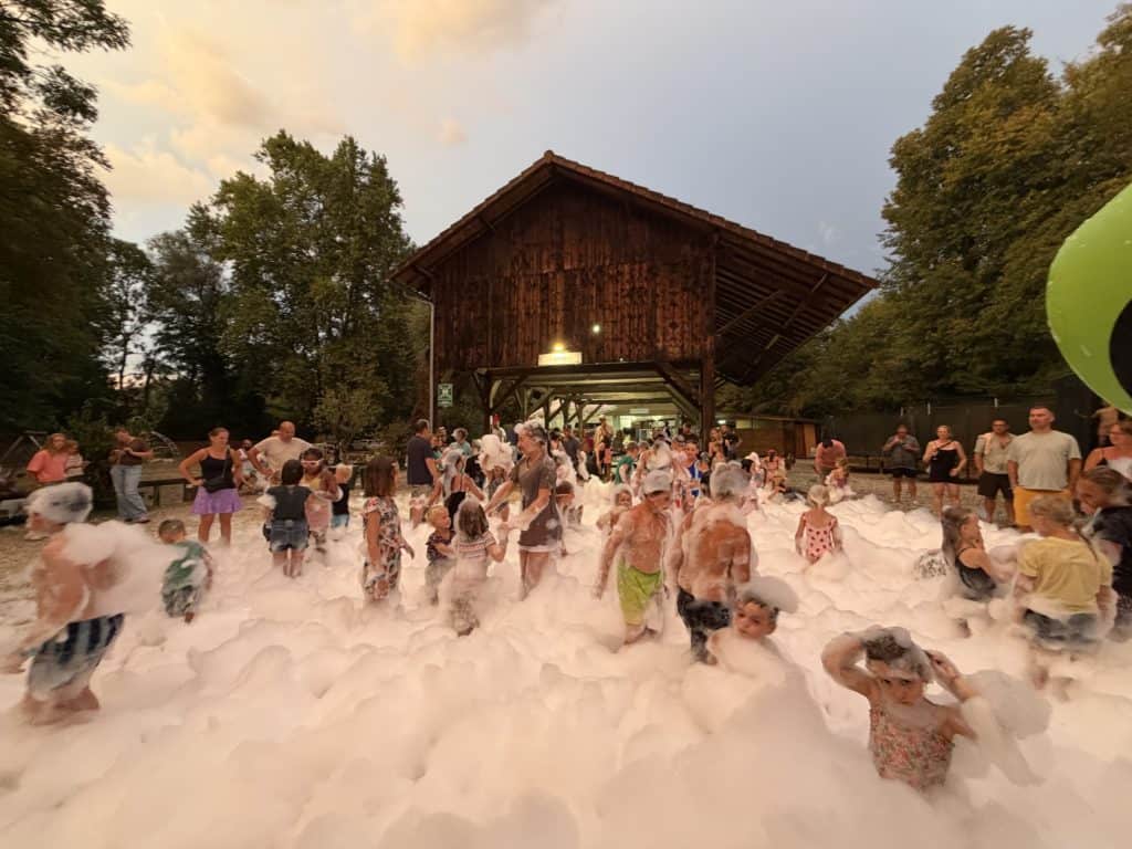 Fête mousse en plein air avec enfants et familles au camping